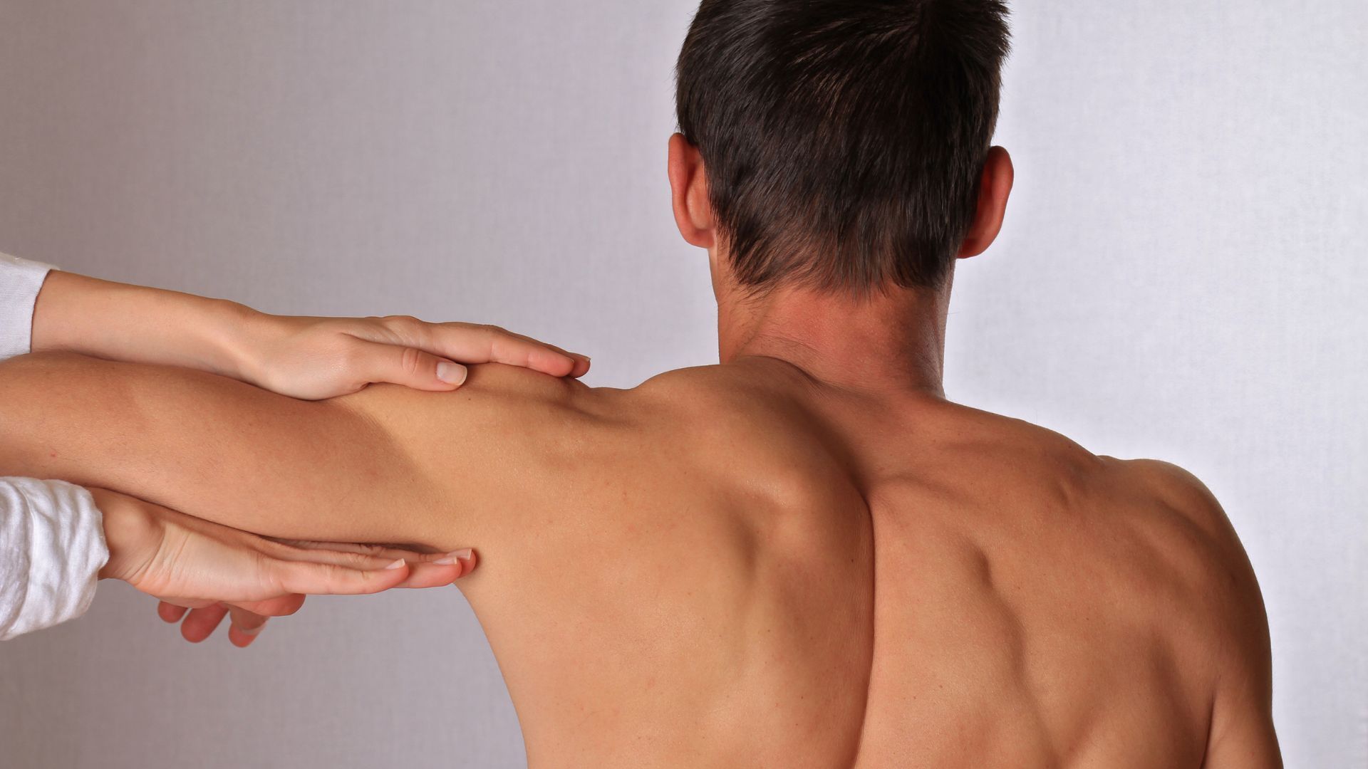 Beneficios de la osteopatía. Ostepata alineando hombro de paciente