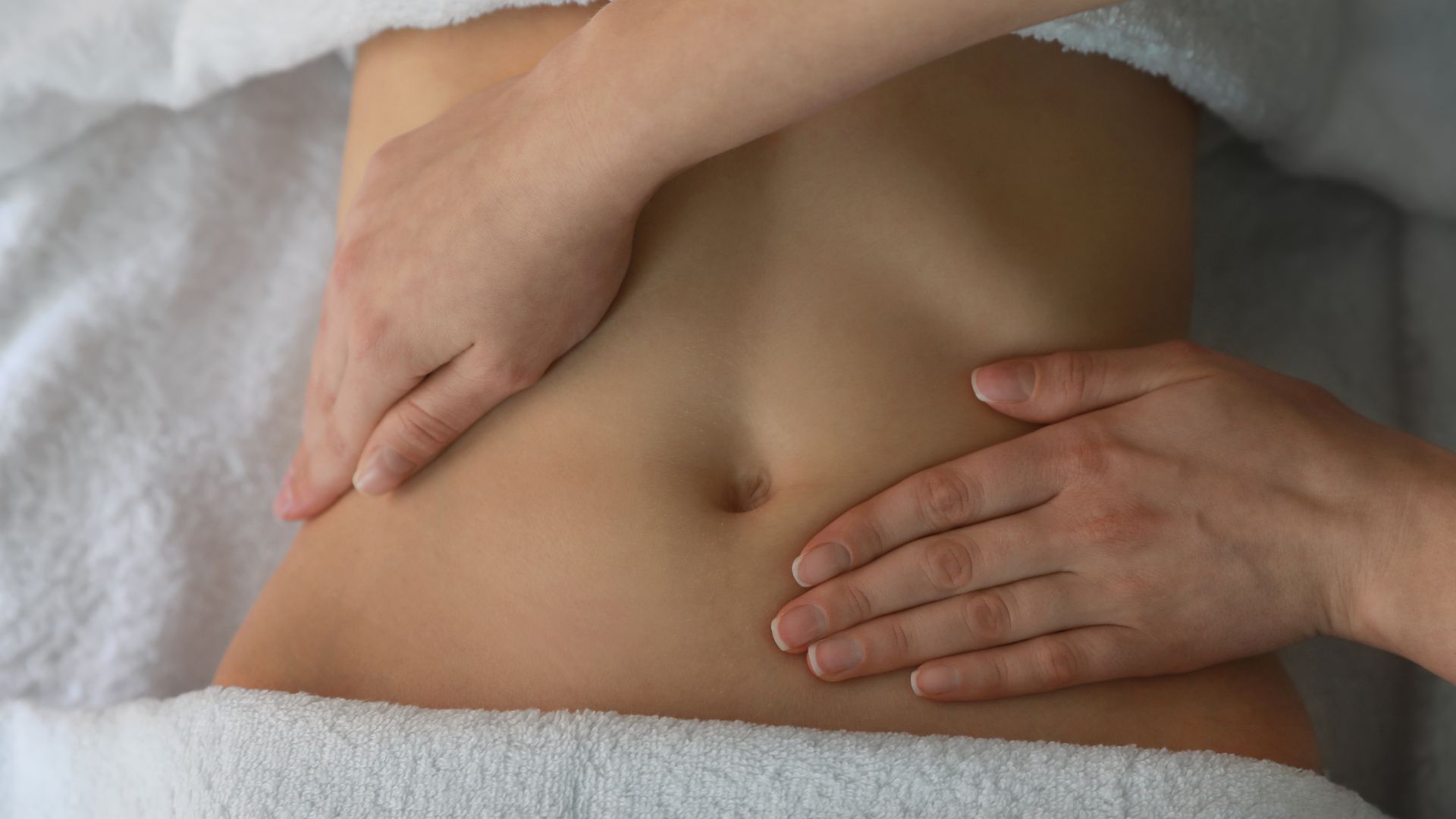 Drenaje linfático en Valencia. mujer recibiendo drenaje linfático manual en la zona abdominal.