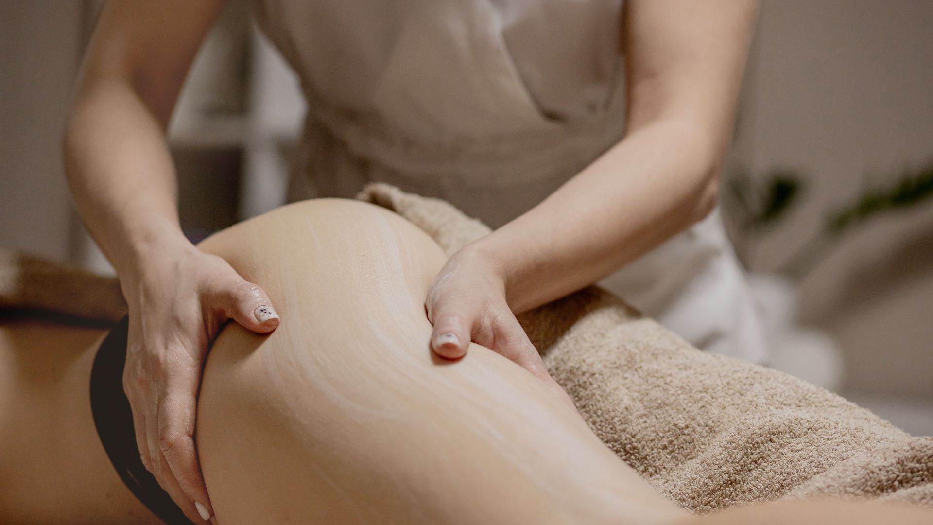 Beneficios del masaje reductor. Terapeuta haciendo masaje reductor en muslos.