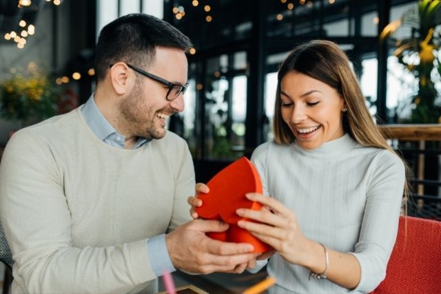 Pareja de hombre y mujer sosteniendo regalo de San Valentin