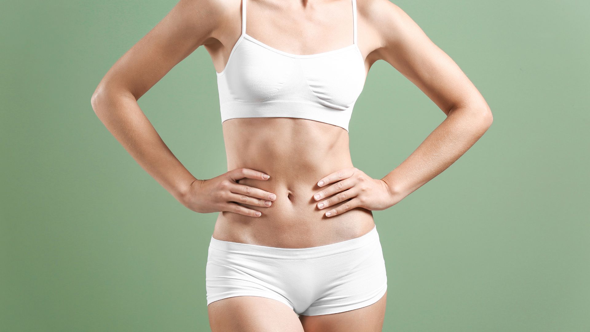 Masaje para la celulitis. Posado de orso de mujer en ropa interior blanca sobre fondo blanco.