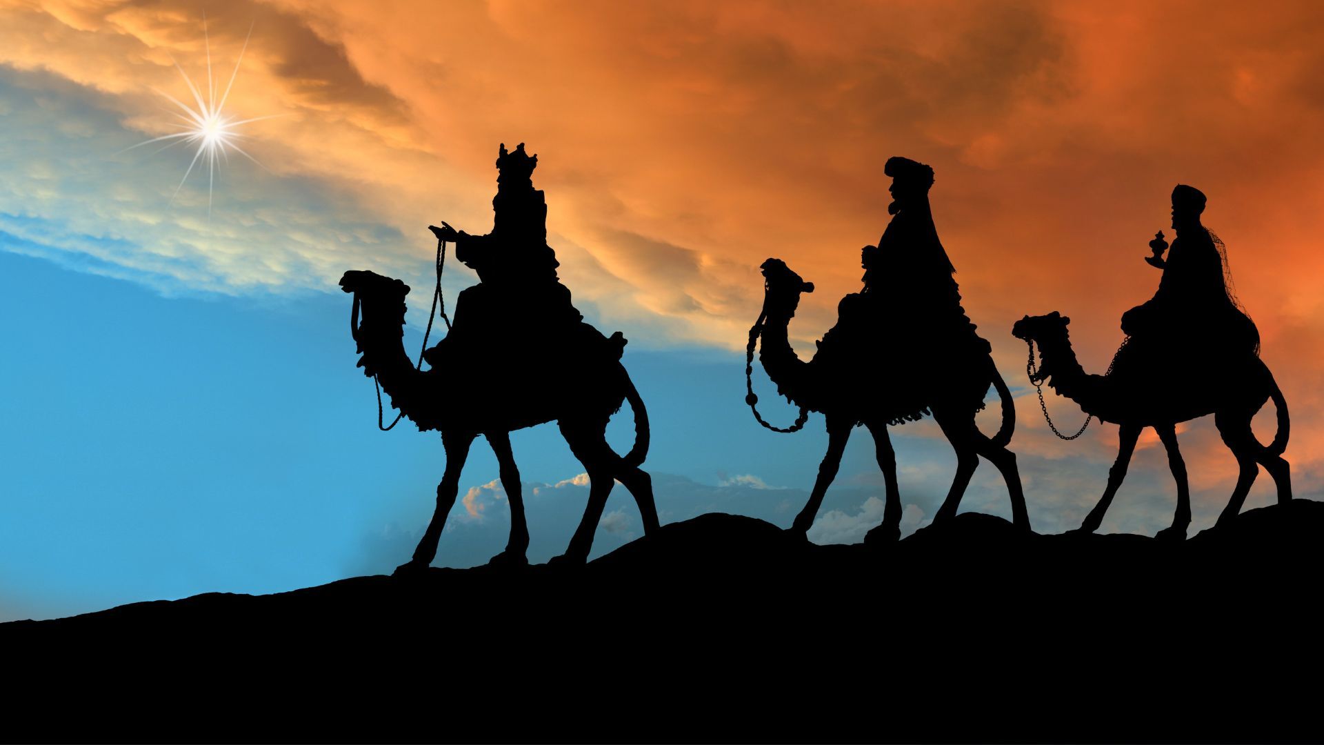 los treyes reyes magos montados en sus camellos siguiendo la estrella de oriente